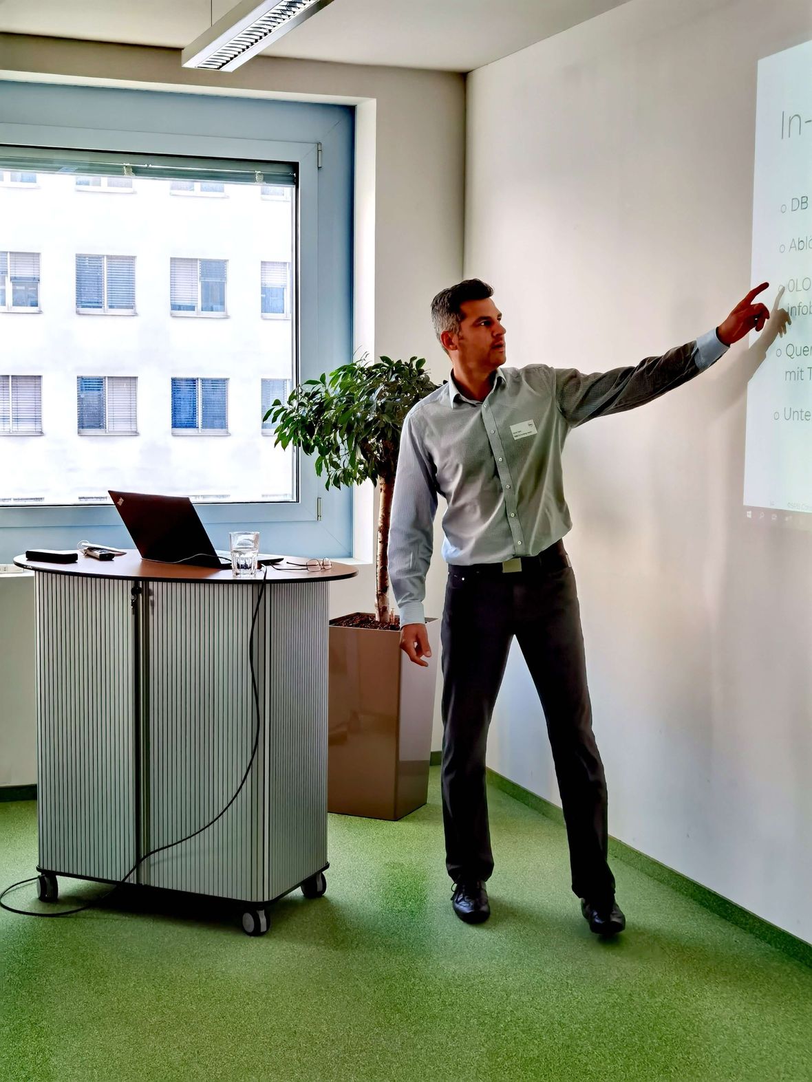 Person zeigt auf Präsentationsbildschirm